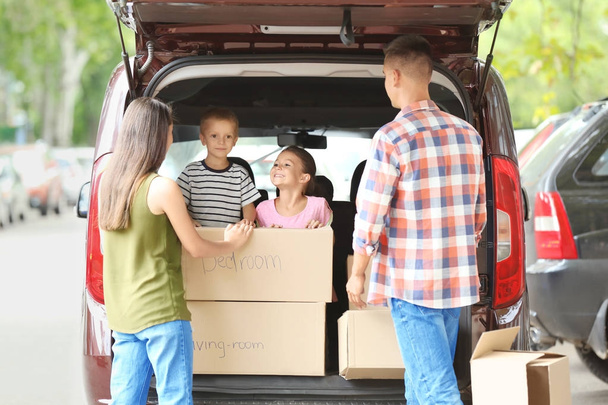 Happy family with boxes near car, outdoors - Zdjęcie, obraz