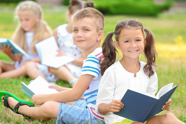 Cute little children reading books in park - Zdjęcie, obraz