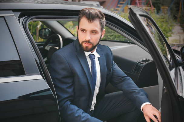 Handsome man in suit getting out of car - Zdjęcie, obraz