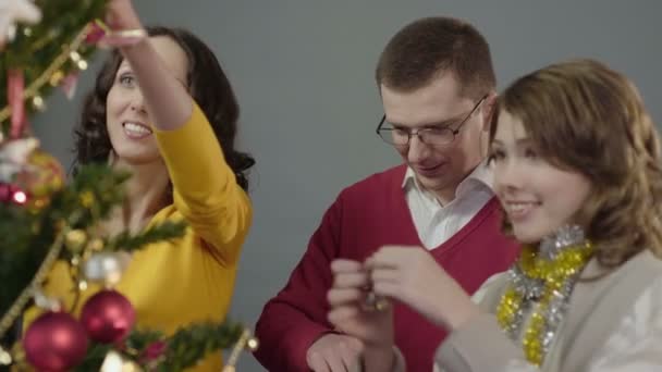 Friendly family joyfully decorating Christmas tree on eve of bright holiday - Πλάνα, βίντεο