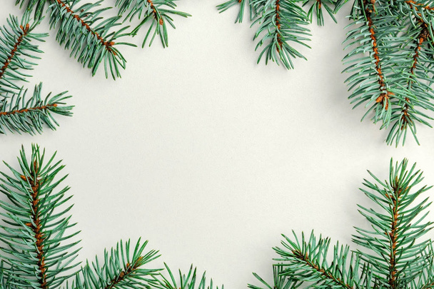 Nový rok, snímek vyrobený z jedlových větví na bílém pozadí. Modré větve vánočního stromu na okrajích bílého pozadí. - Fotografie, Obrázek