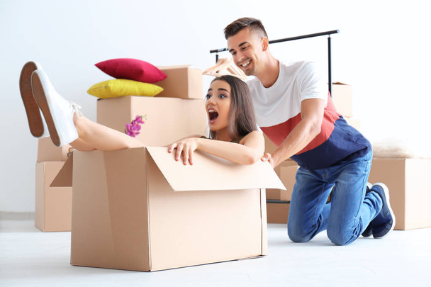 Young happy couple having fun while packing in room - Photo, image