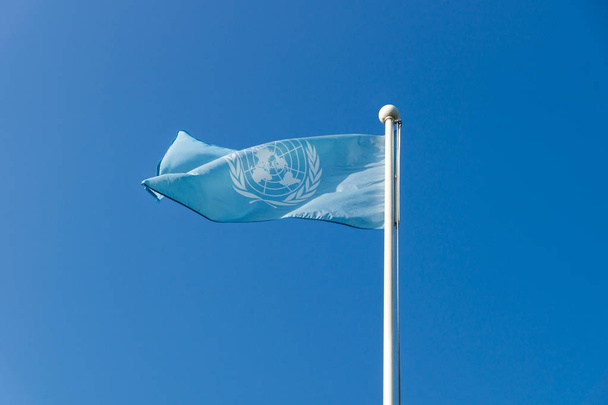 Egyesült Nemzetek ENSZ zászló integet a felhőtlen kék ég Egyesült Nemzetek Memorial temetőben, Busan, Dél-Korea - Fotó, kép