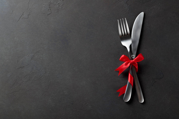 Festive set of cutlery knife and fork with red satin bow, dark s - Photo, Image