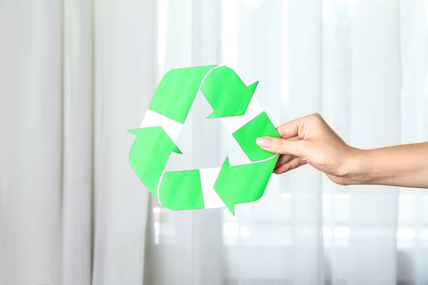 Woman holding symbol of recycling indoors - Фото, изображение