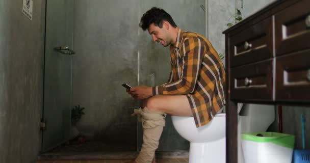 Man Sitting On Toilet Use Cell Smart Phone Young Guy Chatting Online - Кадри, відео