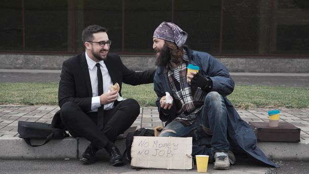 Geschäftsmann kommuniziert mit Obdachlosen - Foto, Bild