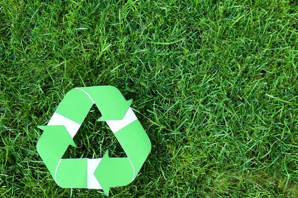 Symbol of recycling on green grass - Zdjęcie, obraz