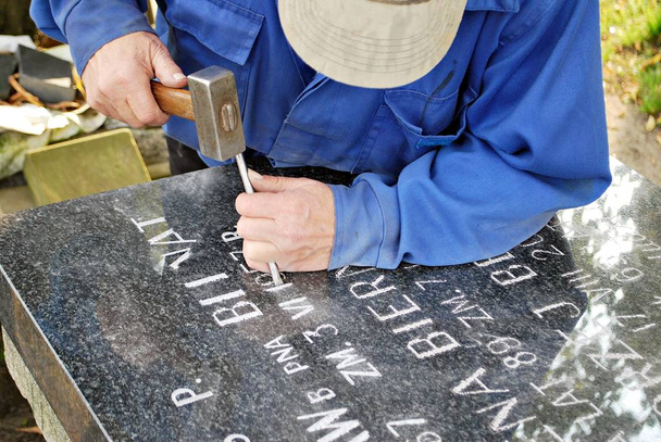 Craftsman working with chisel at tombstone - Photo, Image