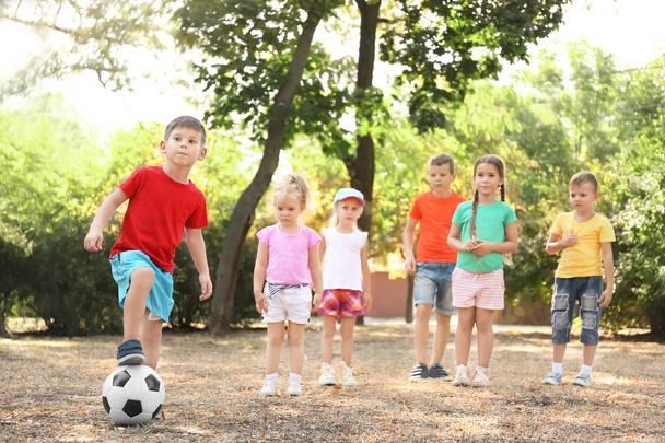 Söpöt lapset pelaavat palloa puistossa
 - Valokuva, kuva
