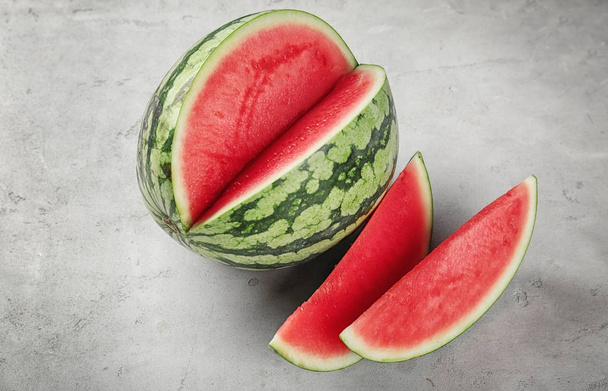 Watermelon with slices on kitchen table - Foto, Imagen