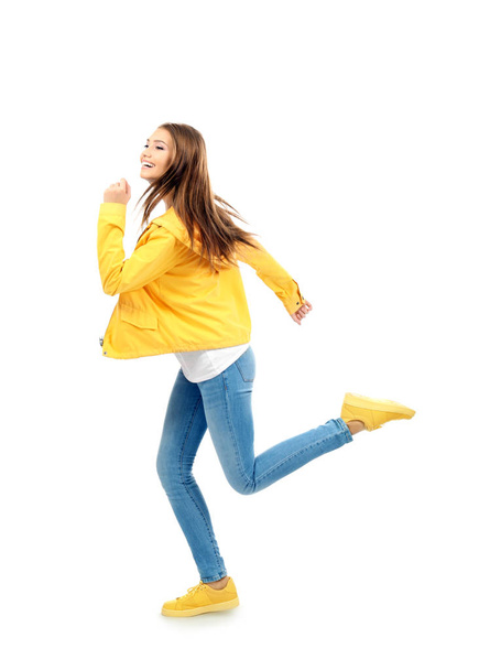 Young woman running on white background - Foto, Imagen