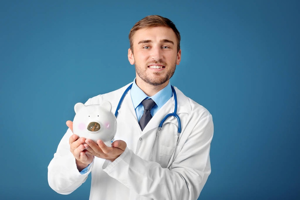Young doctor with piggy bank  - Photo, Image