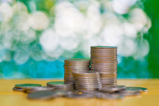 stacks of coins on table in garden with green background, financ - Foto, immagini