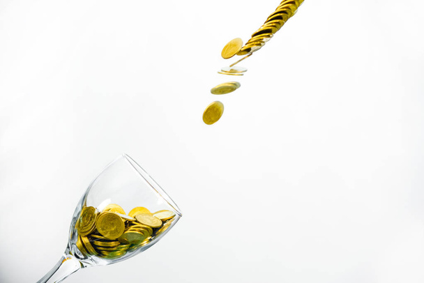 Golden coins splash in a glass of champagne on the wall backgrou - Foto, Imagem