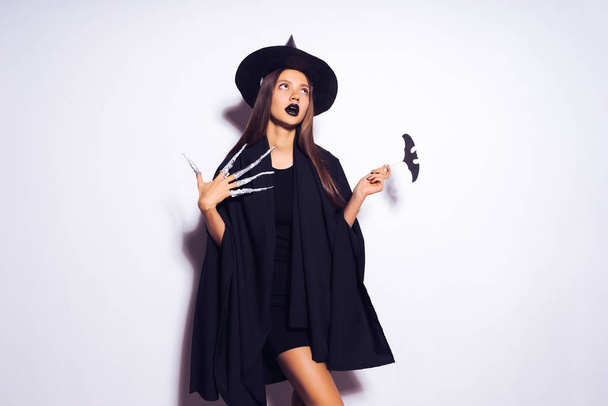 a girl in a witch's costume looks frantically away - Foto, Bild
