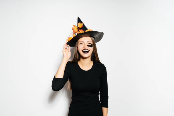 girl in unfinished witch costume on halloween smiling - 写真・画像