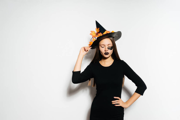 girl in a witch suit wearing a hat on a white background - Foto, Imagen