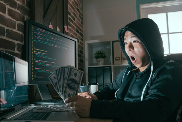 hacker surprised looking at cash banknote - Photo, image