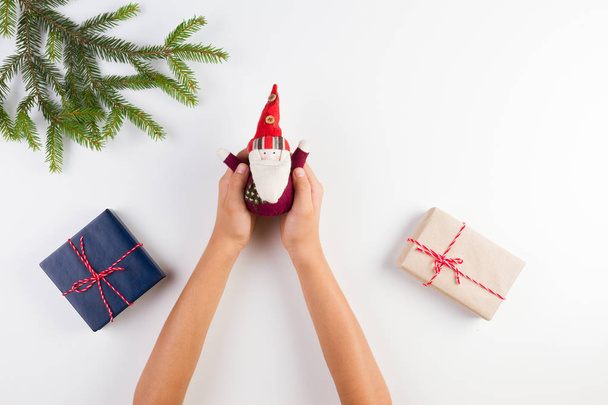 Pohled shora kid pálivých papriček vánoční dekorace. Dárkové krabičky a vánoční stromek větve na bílém stole - Fotografie, Obrázek