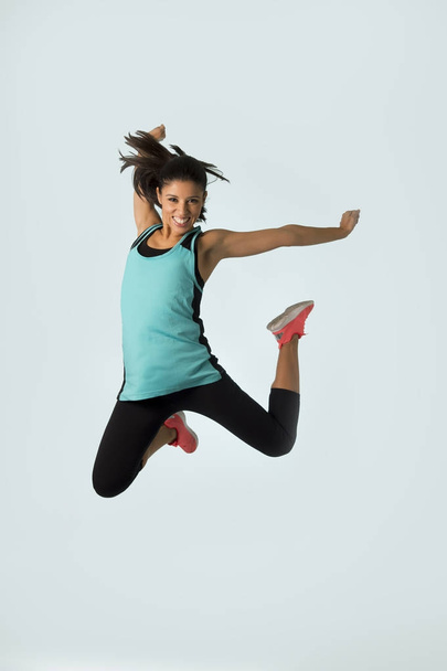 jonge aantrekkelijke en gelukkig Latijnse sport vrouw springen opgewonden en vrolijk in gym oefening training gezonde levensstijl - Foto, afbeelding