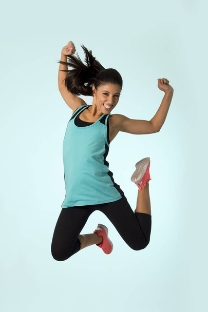young attractive and happy Latin sport woman jumping excited and cheerful in gym exercise workout healthy lifestyle - Fotó, kép