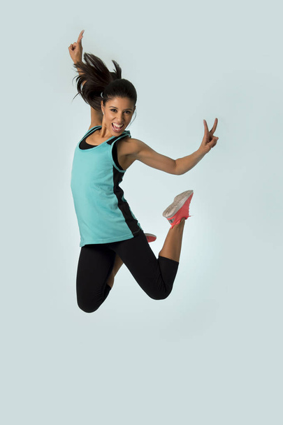 ジャンプの興奮とジム運動ワークアウト健康的なライフ スタイルの陽気な若い魅力的で幸せなラテン スポーツ女性 - 写真・画像