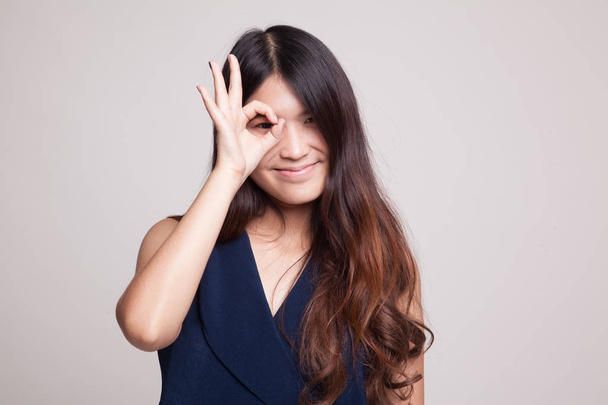 Beautiful young Asian woman show OK sign over her eye. - 写真・画像