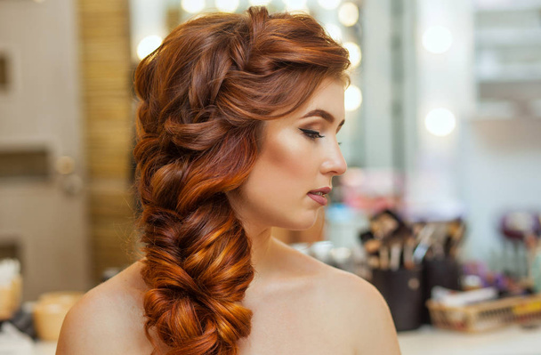 Szép, hosszú, vörös hajú szőrös lány fodrász sző egy francia zsinór - Fotó, kép