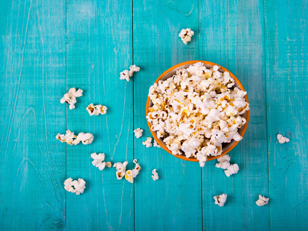 popcorn kukurydza na niebieskim tle drewnianych, jako przekąskę do oglądania filmów - Zdjęcie, obraz