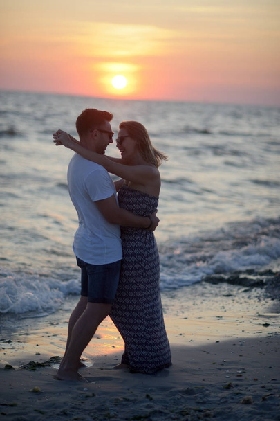 Couple of lovers stands having embraced on the seashore. - Φωτογραφία, εικόνα