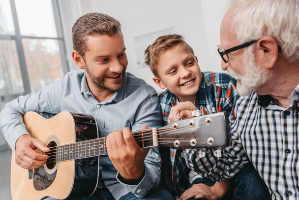 Člověk hrát na kytaru s rodinou doma - Fotografie, Obrázek