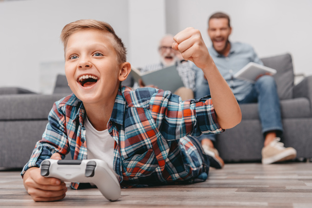 Cheering boy jouer à des jeux vidéo avec manette de jeu
 - Photo, image