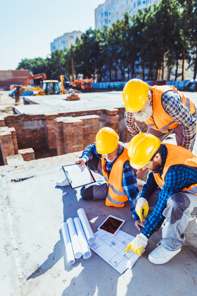 Trabajadores de la construcción examinando planos
 - Foto, Imagen