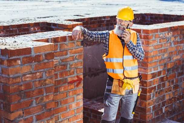 Travailleur de la construction parlant à la radio portable
 - Photo, image