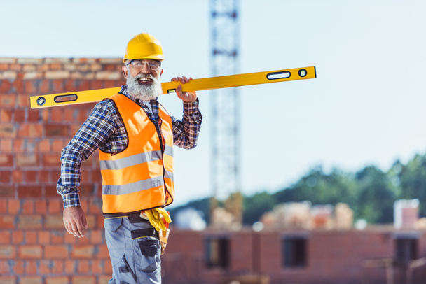 Usmívající se stavební dělník s vodováhou - Fotografie, Obrázek