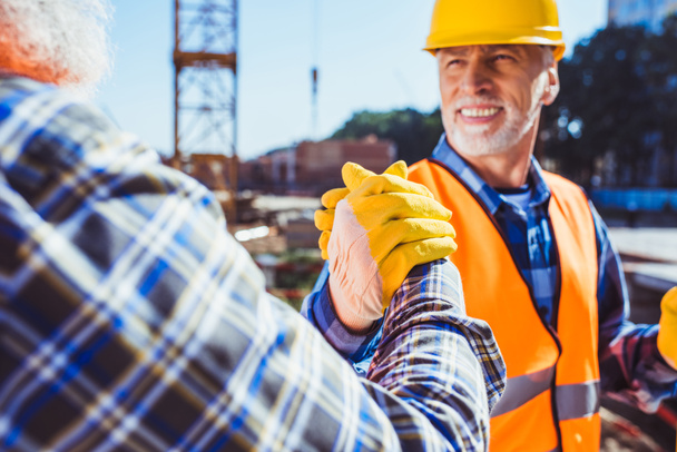 Trabajadores de la construcción estrechando manos
 - Foto, imagen