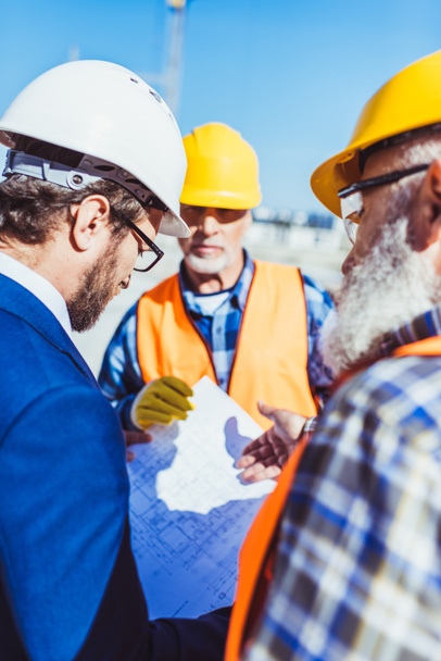 Constructores y hombres de negocios discutiendo planes de construcción
 - Foto, Imagen