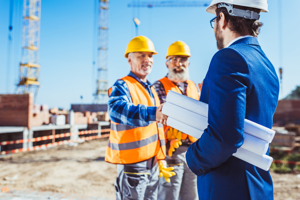 建設労働者と握手するビジネスマン - 写真・画像