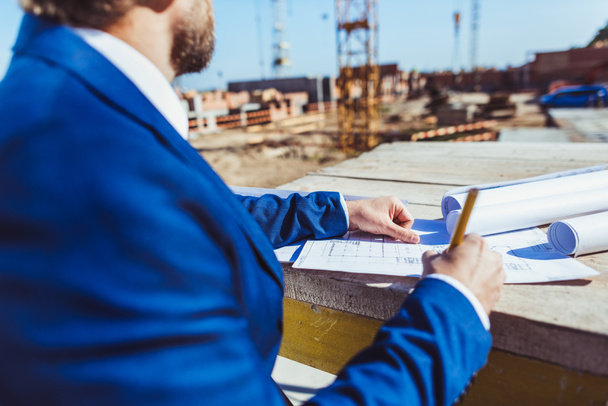 Businessman taking notes at construction site - Photo, Image