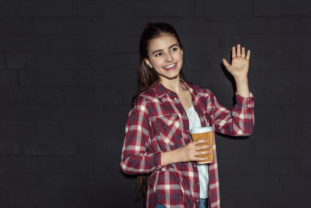 chica con café agitando la mano
 - Foto, Imagen