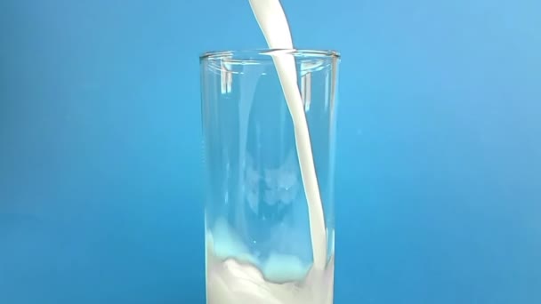 fresh white milk pouring into drinking glass on chroma key blue screen background, shooting with slow motion, diet and healthy nutrition  - Imágenes, Vídeo