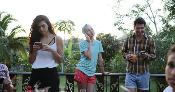 Menschen nutzen Mobiltelefone im Gespräch am Tisch im Freien auf der Terrasse junge Freunde glücklich lächelnd Social-Media-Kommunikation - Filmmaterial, Video