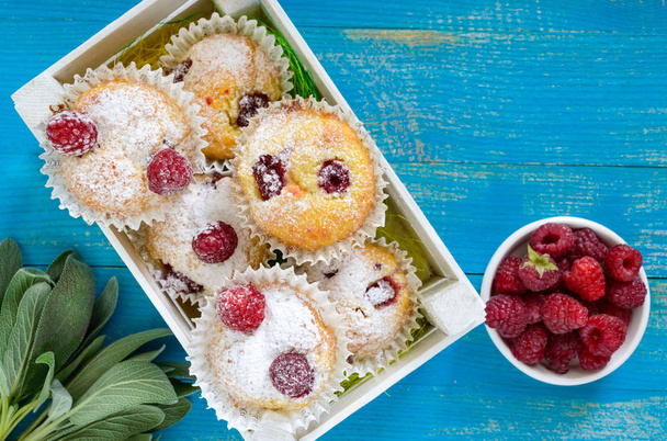 Gâteaux caillés (muffins) aux framboises, décorés de sucre en poudre
 - Photo, image