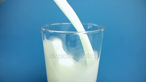 fresh white milk pouring into drinking glass on chroma key blue screen background, shooting with slow motion, diet and healthy nutrition  - Кадри, відео