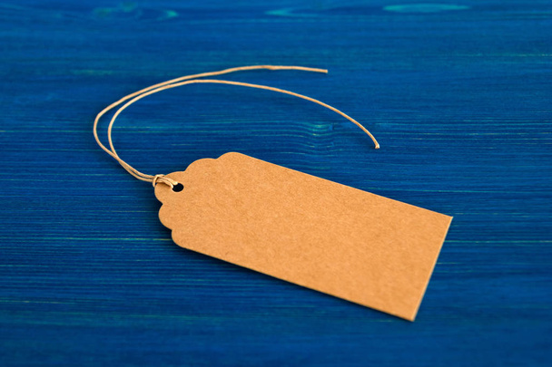 Brown blank paper price tag or label set on the blue wooden background, top view. - Photo, Image