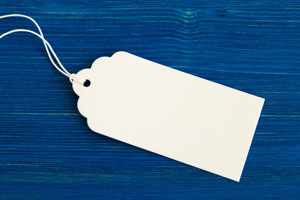 White blank paper price tag or label set on the blue wooden background, closeup. - 写真・画像