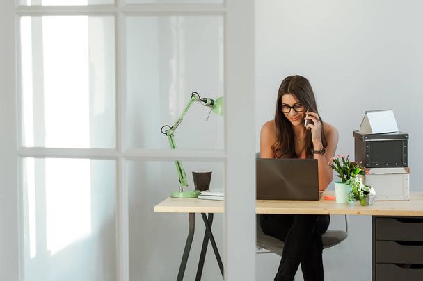 Зайнята жінка сидить на робочому столі
 - Фото, зображення