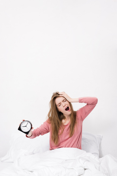 sleepy woman with alarm clock - Valokuva, kuva
