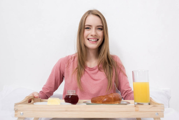 happy woman with breakfast on wooden tray - Foto, Imagem